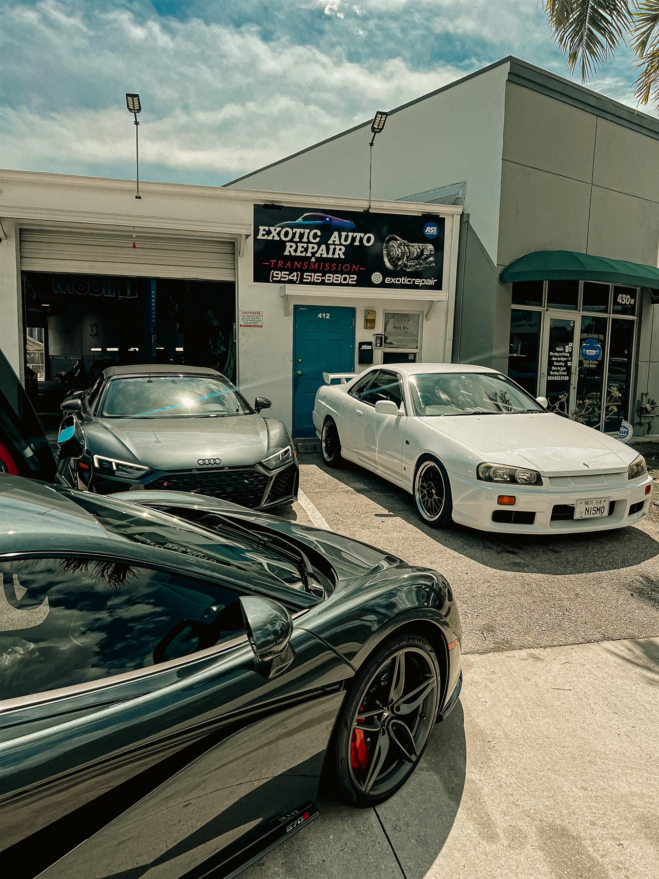 Exotic repair shop exterior with performance vehicles