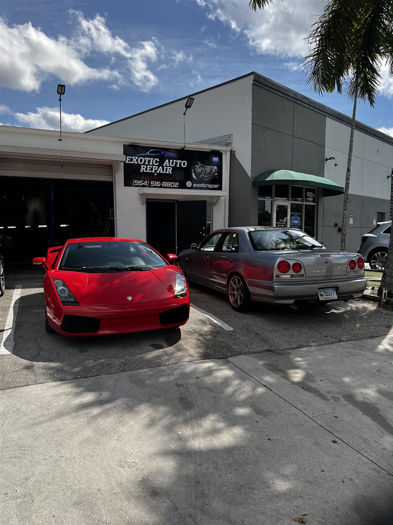 Red Lamborghini parked outside the exotic auto repair shop