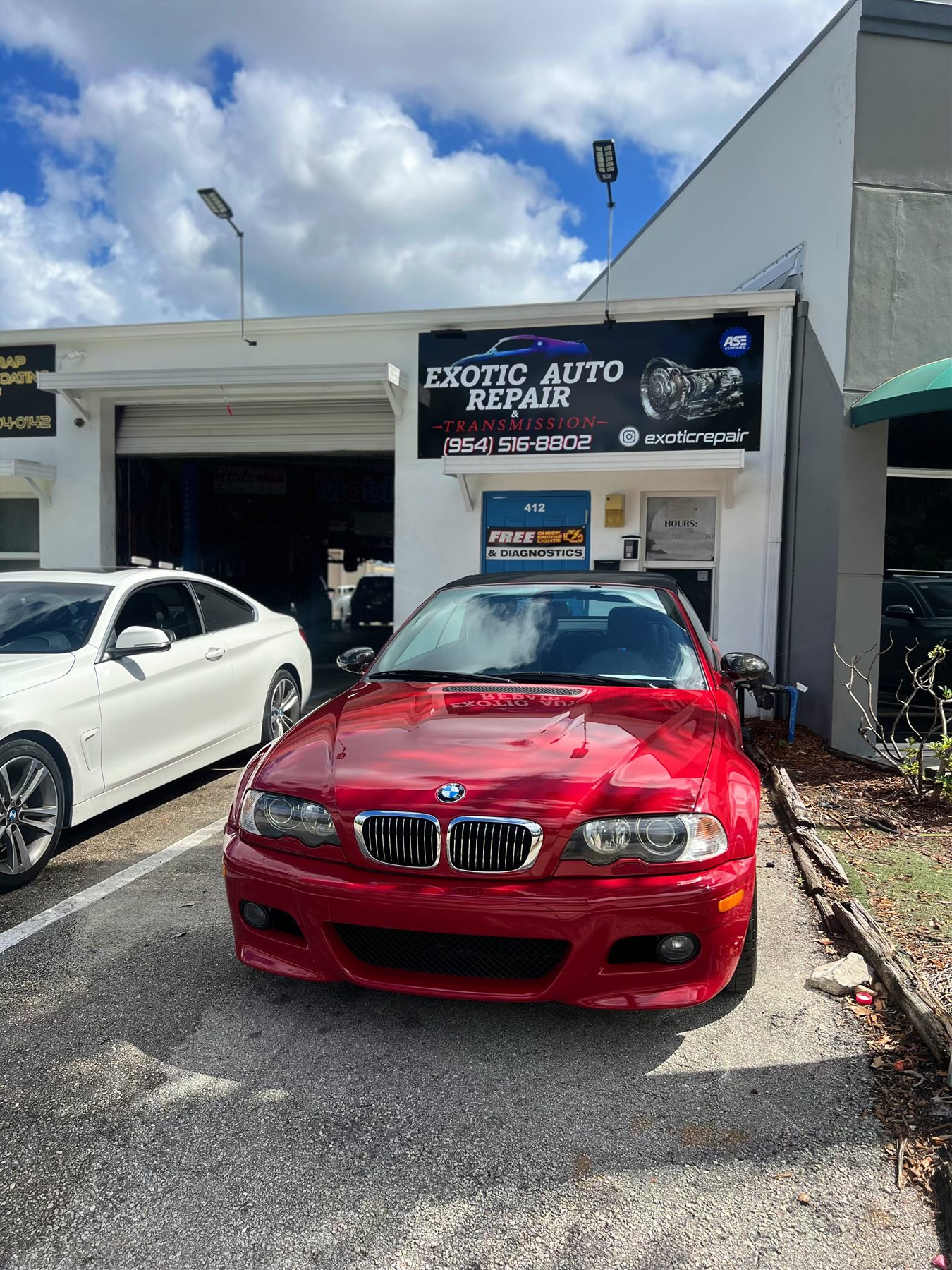 Red BMW M car outside the shop entrance