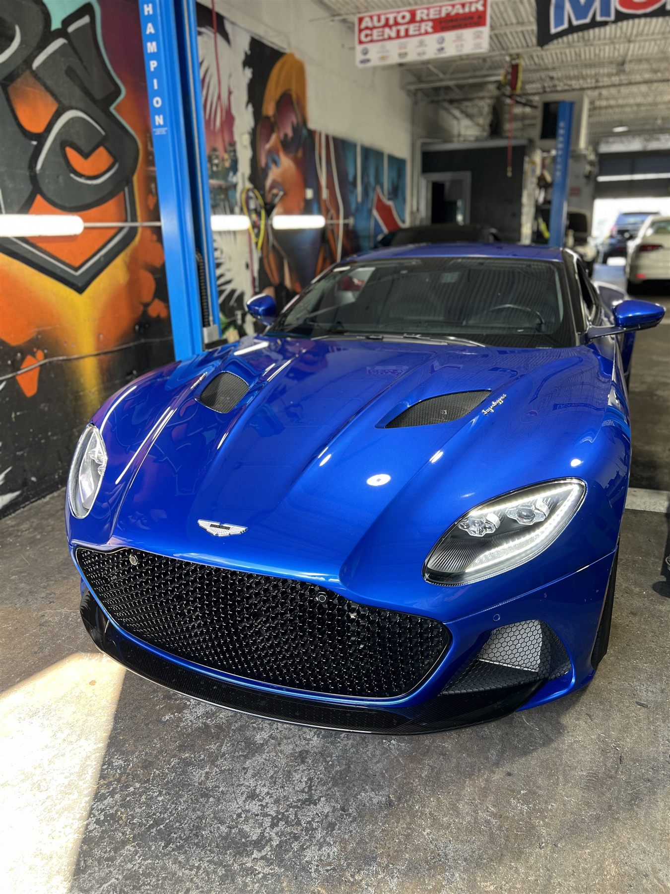 Blue Aston Martin performance car inside the shop