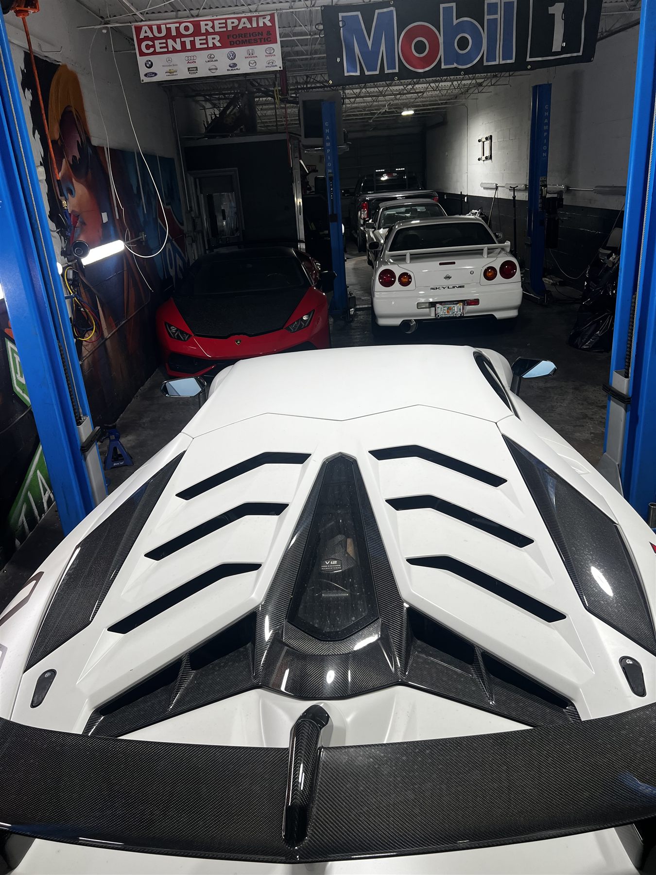 White Lamborghini with carbon fiber engine cover in the shop