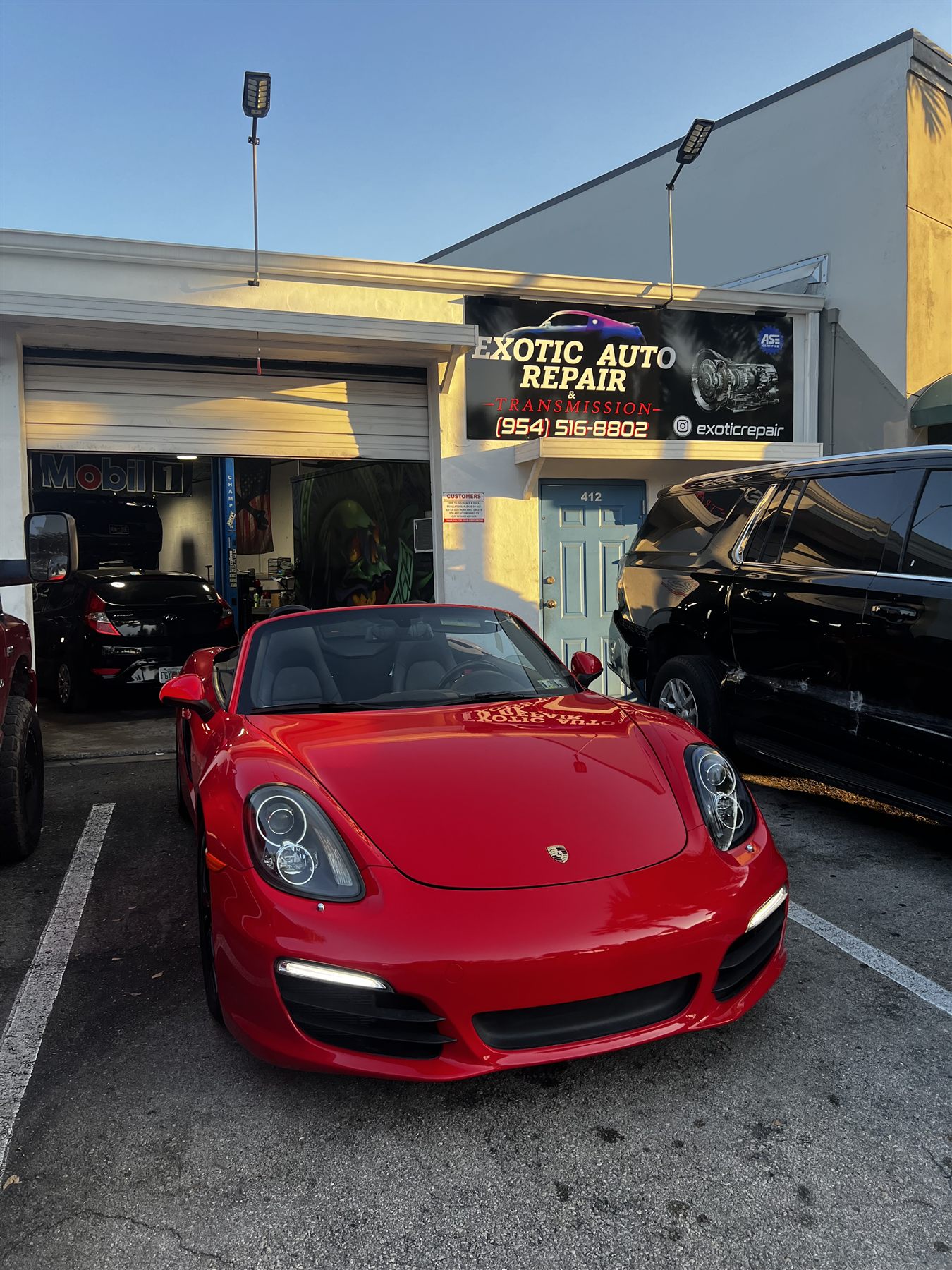 Red Porsche parked outside the exotic auto repair shop